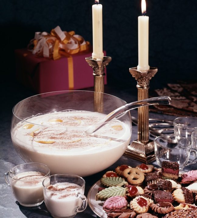 Eggnog on a table with lit candles.