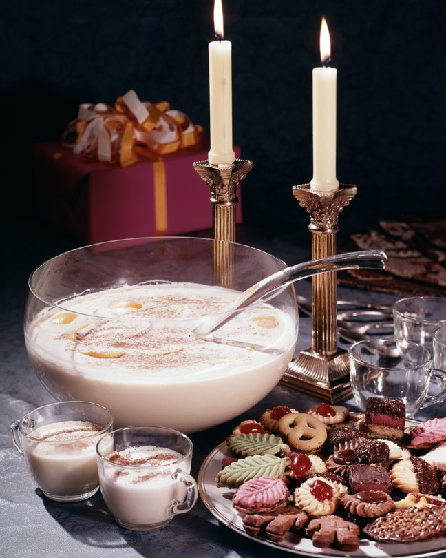 Eggnog on a table with lit candles.