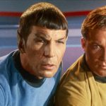 Spock and Captain James T. Kirk lean in to look intently at a screen