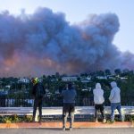 A photo of people in L.A. watching the wildfire rampaging across the hillsides.