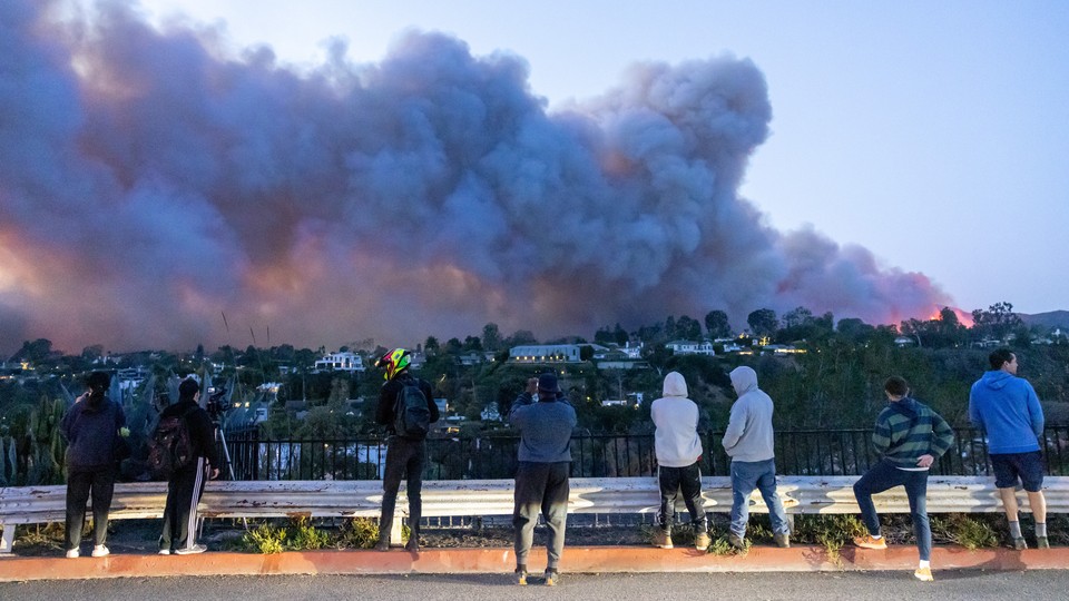 A photo of people in L.A. watching the wildfire rampaging across the hillsides.